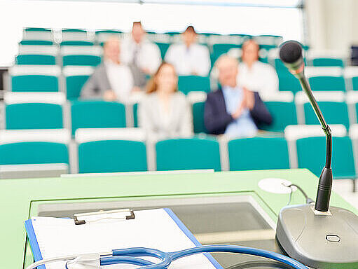 Vortrag, Pult und Mikrofon im Vordergrund Vortragssaal, Pult und Mikrofon im Vordergrund
