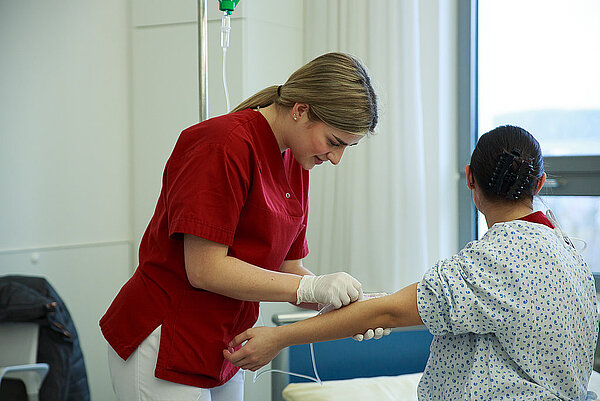 Pflegefachkraft nimmt beim Patienten Blut ab