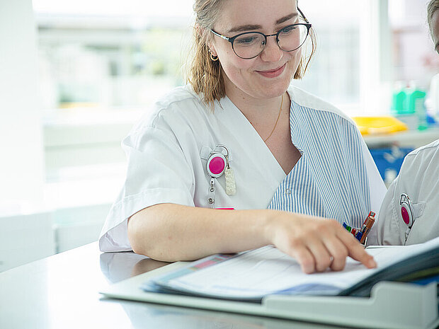 Pflegekraft beim Durchsehen einer Patientenakte Pflegekraft beim Durchsehen einer Patientenakte