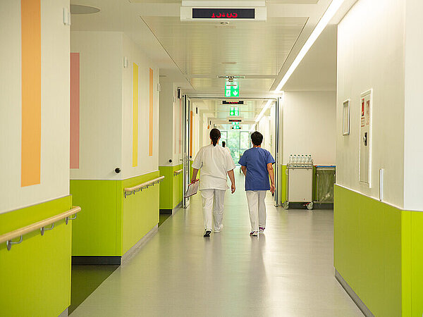 Zwei Mitarbeiterinnen auf dem Stationsflur Zwei Mitarbeiterinnen auf dem Stationsflur