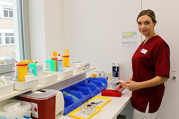 Eine medizinische Fachkraft steht an einem Labortisch mit Proben und Materialien