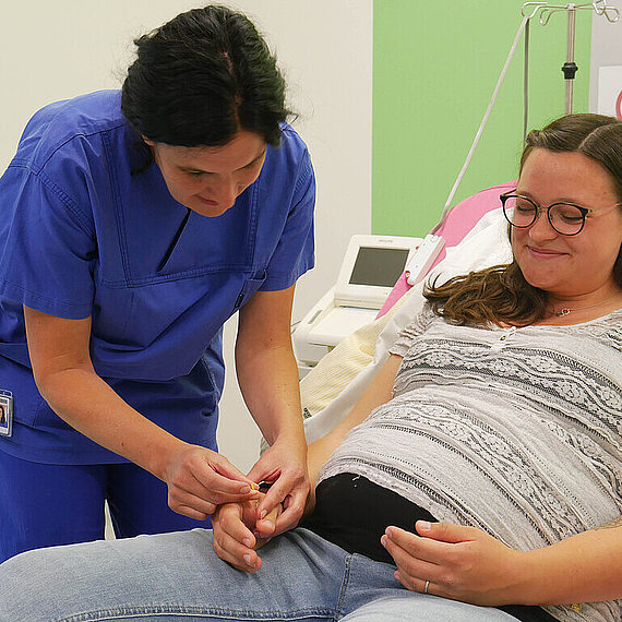 Hebamme bei der Akupunktur mit einer Schwangeren Hebamme bei der Akupunktur mit einer Schwangeren