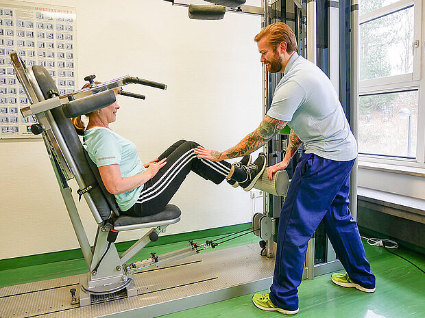 Physiotherapeut mit Patientin am Gerät Physiotherapeut mit Patientin am Gerät