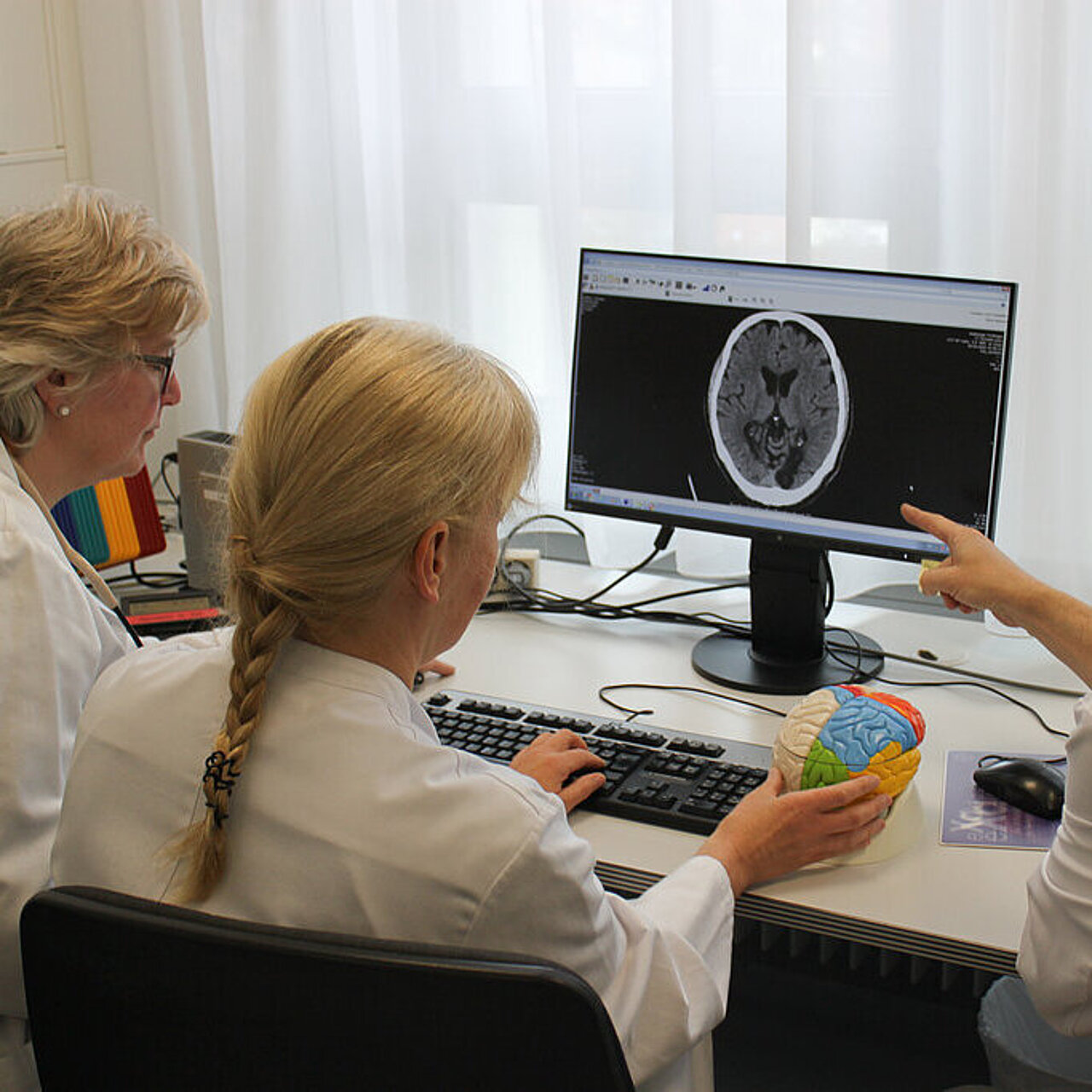 Drei Ärzte besprechen einen Befund am Schreibtisch Drei Ärzte besprechen einen Befund am Schreibtisch