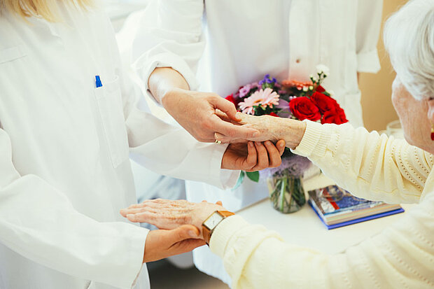 Ärztinnen bei einer Patientin am Bett Ärztinnen bei einer Patientin am Bett