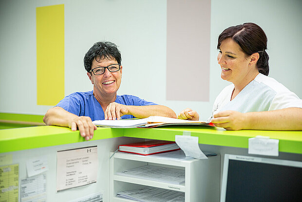 Zwei Mitarbeiterinnen am Stationstresen Zwei Mitarbeiterinnen am Stationstresen
