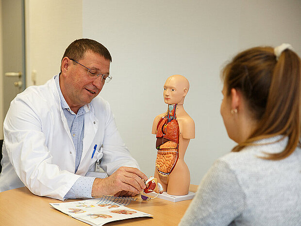 Chefarzt Valery Kravtsunov berät eine Patientin Chefarzt Valery Kravtsunov berät eine Patientin