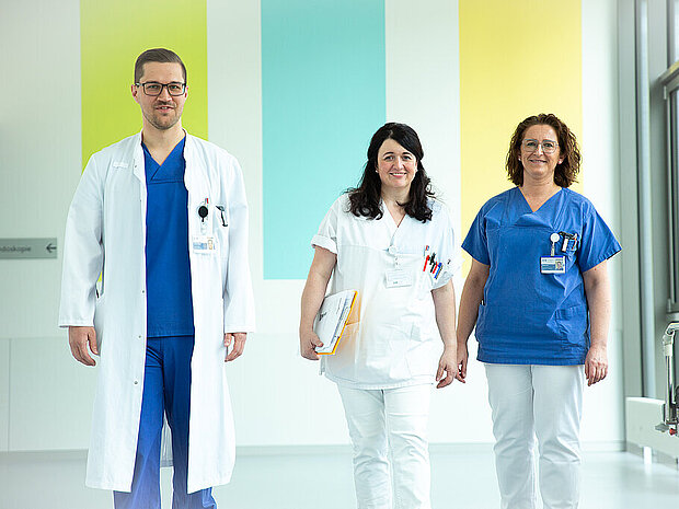 Drei Mitarbeitende auf dem Stationsflur Drei Mitarbeitende auf dem Stationsflur
