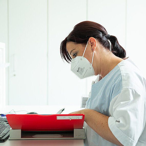 Pflegekraft bei der Durchsicht einer Patientenakte Pflegekraft bei der Durchsicht einer Patientenakte